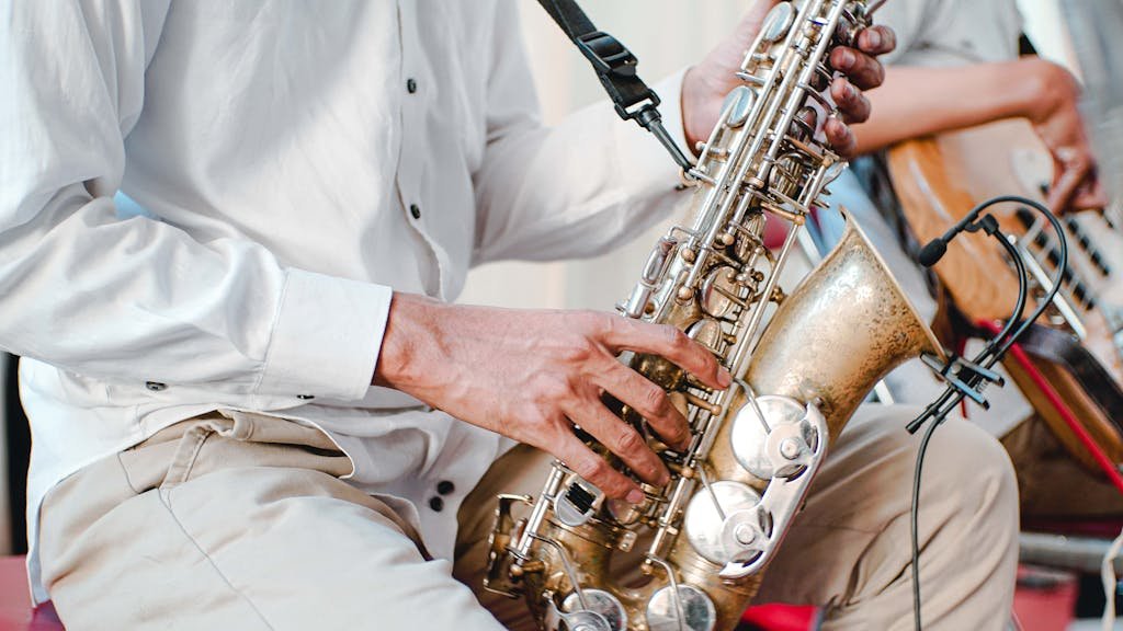 Detailed shot of a musician playing a saxophone during a performance. Captures the essence of live music.