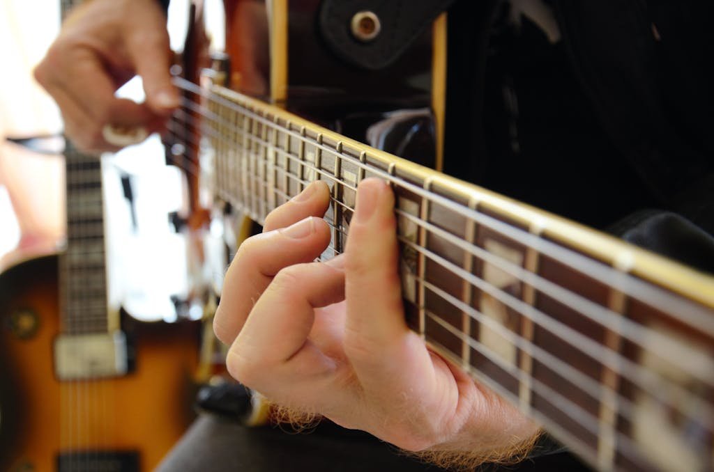 A focused shot of a musician skillfully playing an electric guitar, capturing their detailed hand movements.